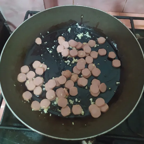 Cincang bawang putih, kemudian tumis dengan olive oil hingga harum. Masukkan irisan sosis. Setelah wangi, matikan kompor dan sisihkan.
