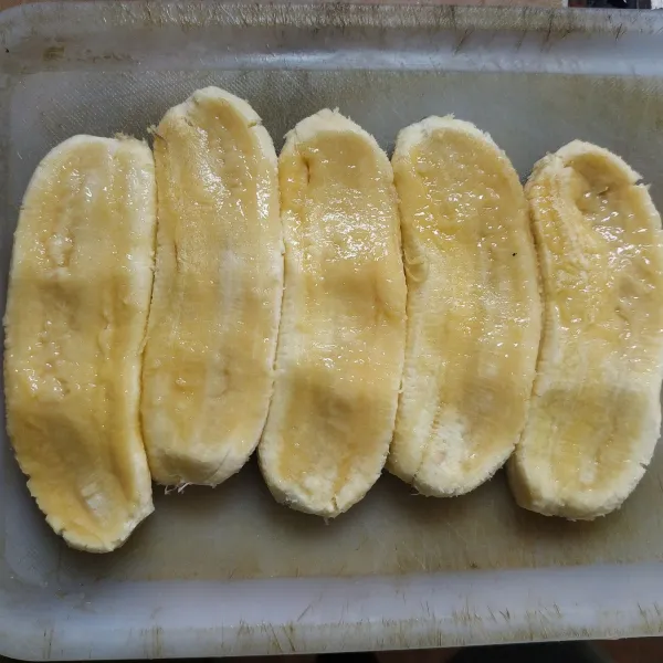 Cuci pisang, kupas lalu pipihkan menggunakan ulekan.