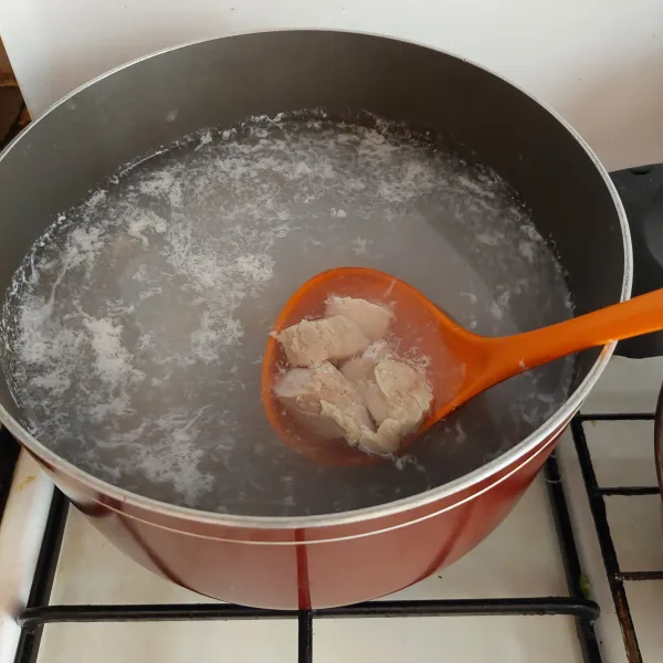 Didihkan air, lalu masukkan ayam yang sudah dipotong.