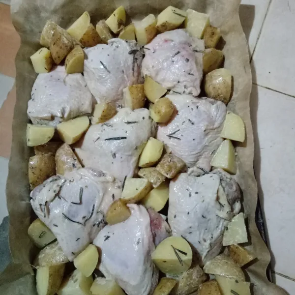 Siapkan loyang yang sudah di alasi silpat atau aluminium foil, lalu tata ayam dan kentang.