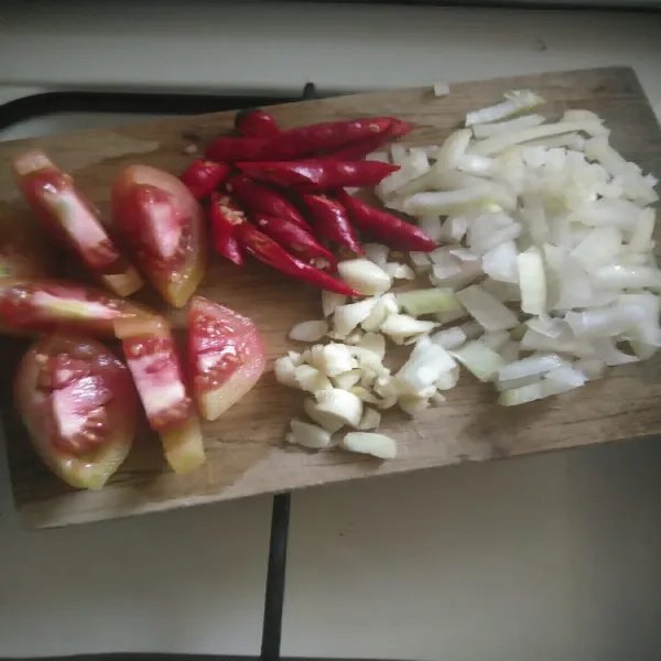 Potong bawang bombay, bawang putih, tomat, dan cabai merah.