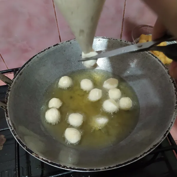 Kempiskan adonan, lalu masukkan ke dalam piping bag. Semprot dan gunting di atas minyak yang sudah dipanaskan. Aduk supaya matang merata, lalu angkat dan tiriskan.