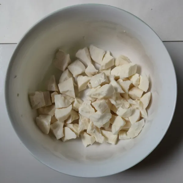 Kupas singkong, cuci bersih, lalu potong-potong.