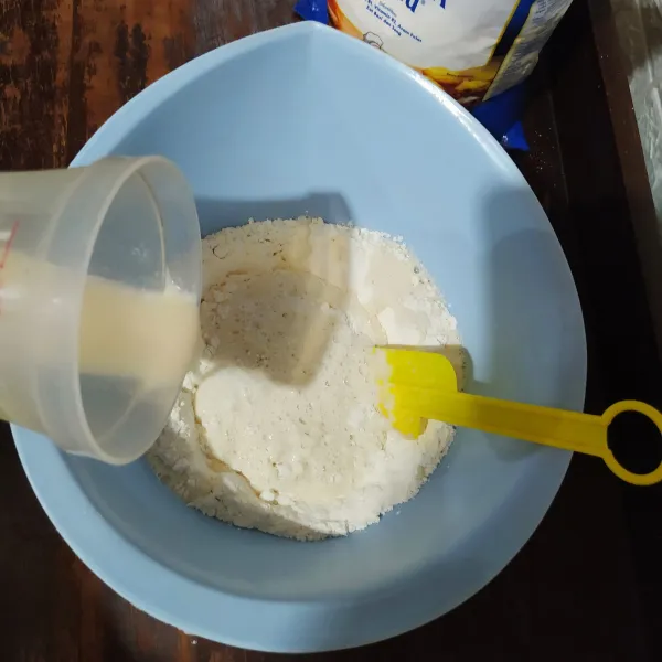 Tuang adonan biang ke dalam tepung terigu, lalu aduk rata.