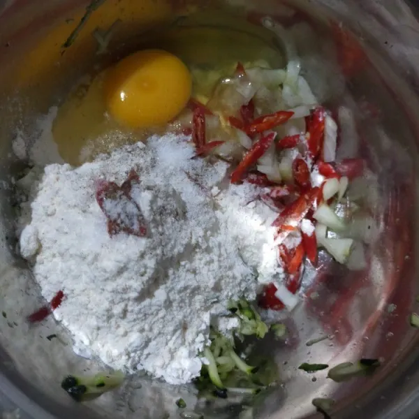 Dalam mangkuk, masukkan zucchini, bawang bombay, tepung terigu, tepung maizena, cabai merah, telur dan lada bubuk. Aduk rata.