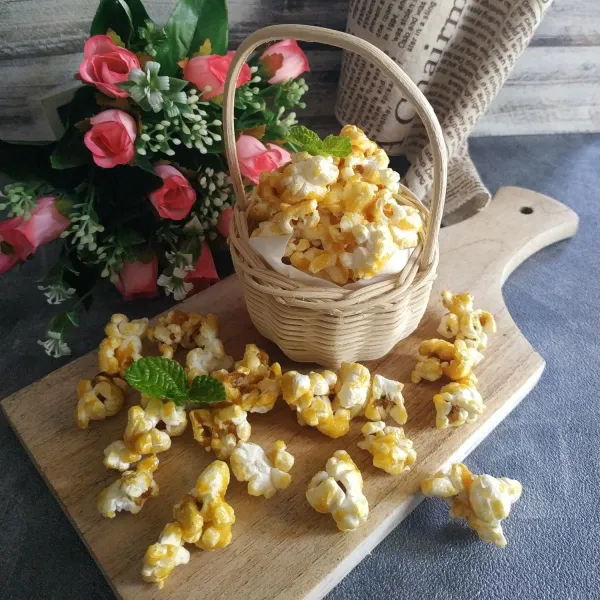 Masukkan jagung kedalam wadah besar tuang keatas popcorn sambil terus diaduk dengan cepat dan rata. Popcorn siap disajikan.