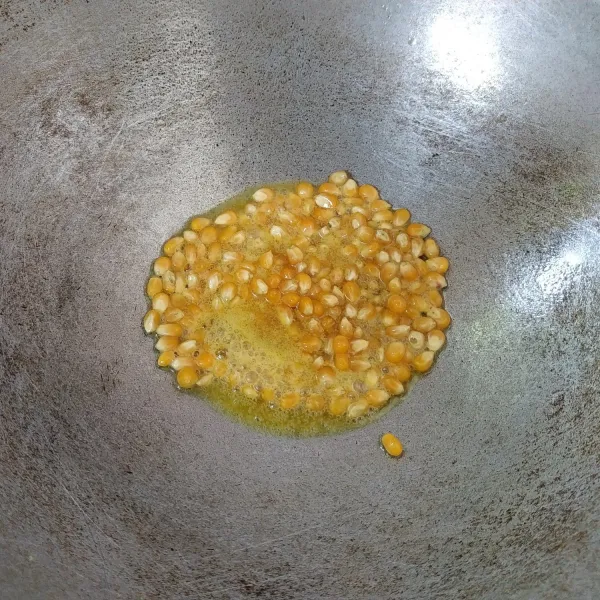 Panaskan 2 sdm butter, kemudian masukkan jagung dan aduk-aduk kemudian tutup. Masak jagung hingga menjadi popcorn.