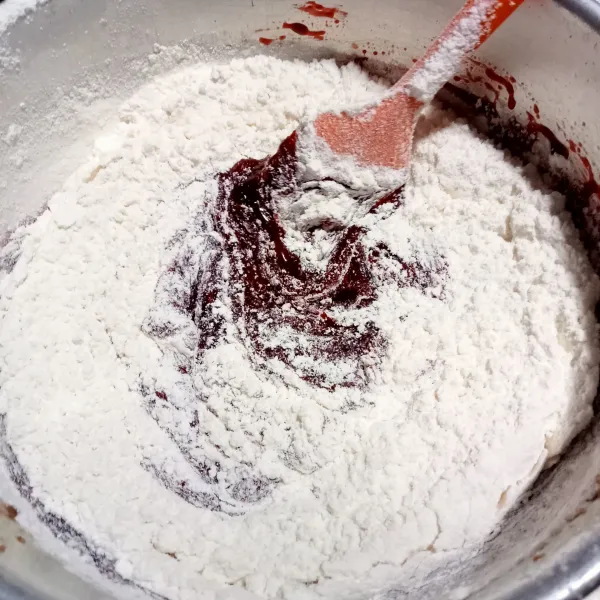 Tambahkan pasta vanila dan red Velvet, lalu aduk rata. Kemudian masukkan tepung bertahap, soda kue, dan garam.