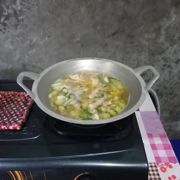 Masukkan air asam. Bumbui dengan garam, gula, dan penyedap rasa. Masak sampai terong matang.