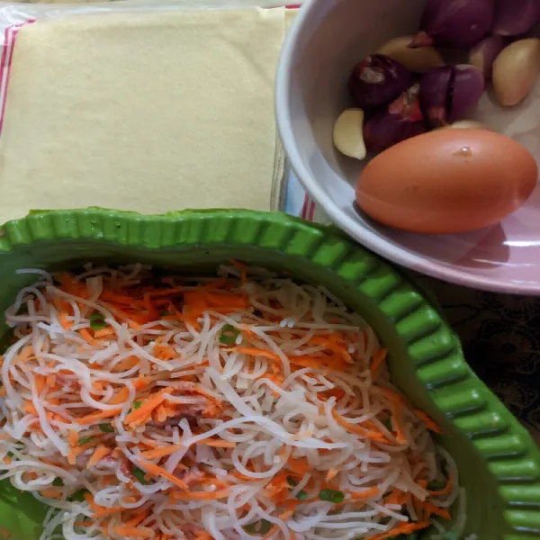 Siapkan semua bahan dan bumbu, rendam bihun jagung dengan air panas lalu tiriskan, parut wortel, dan potong daun bawang.