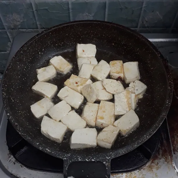 Tahu digoreng hingga kecoklatan.