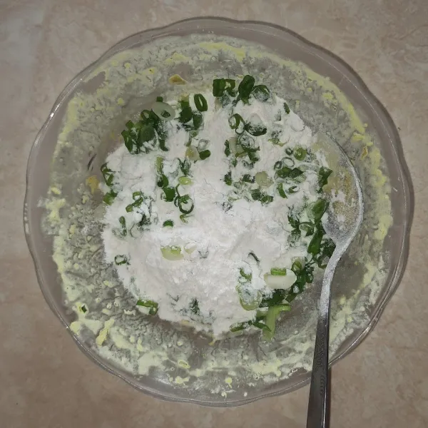 Masukkan tepung serba guna dan daun bawang.