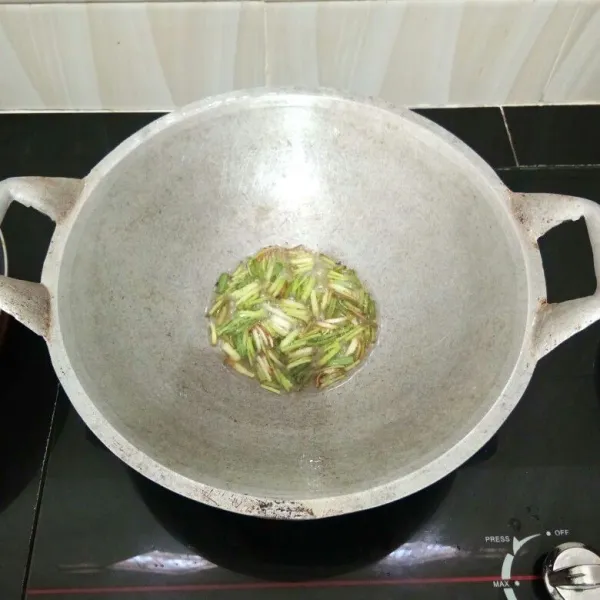 Panaskan secukupnya minyak, goreng daun bawang hingga kecokelatan.