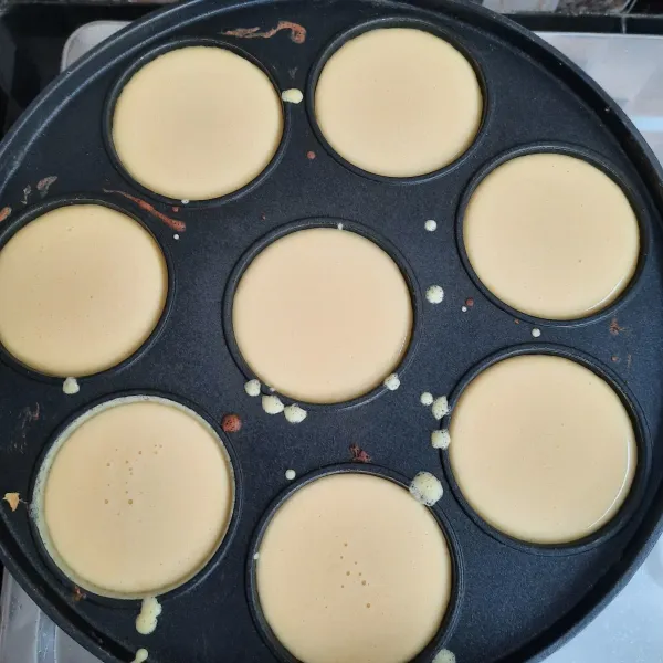 Panaskan cetakan kue lumpur, tuang adonan. Panggang hingga bagian atas setengah set, kemudian beri topping. Panggang hingga matang, angkat dan sajikan.
