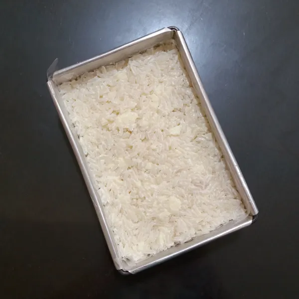Tata beras ketan di loyang, padatkan.