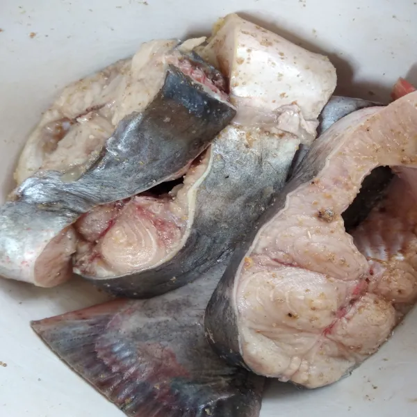 Cuci bersih ikan patin, kemudian campurkan dengan air jeruk nipis dan ketumbar bubuk. Marinasi selama 25 menit.