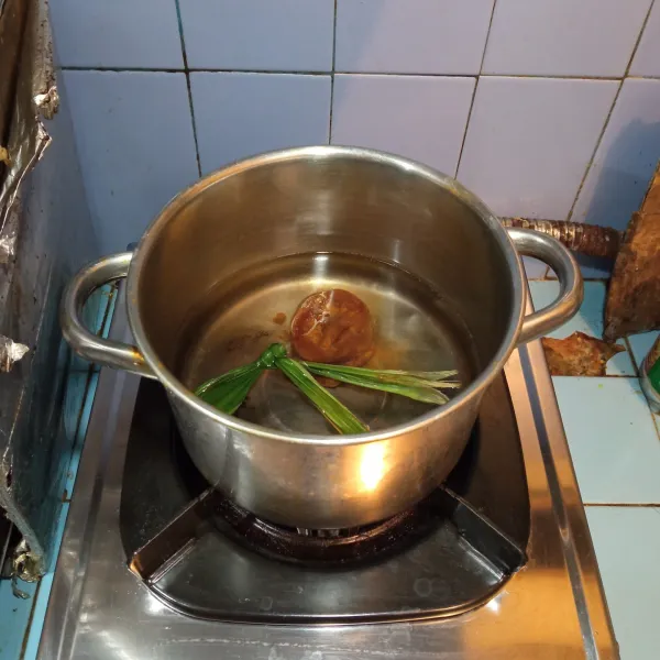 Panaskan air dalam panci, kemudian masukkan gula merah dan daun pandan, masak hingga mendidih.