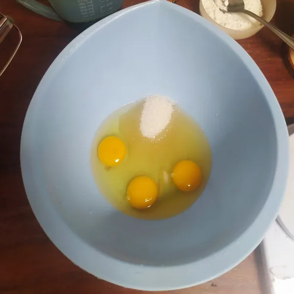 Masukkan gula, garam, dan telur ke dalam wadah lalu aduk dengan balloon whisk hingga gula larut.