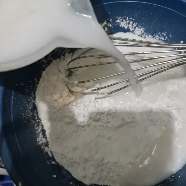 Masukkan santan ke dalam bahan kering, lalu aduk hingga rata.