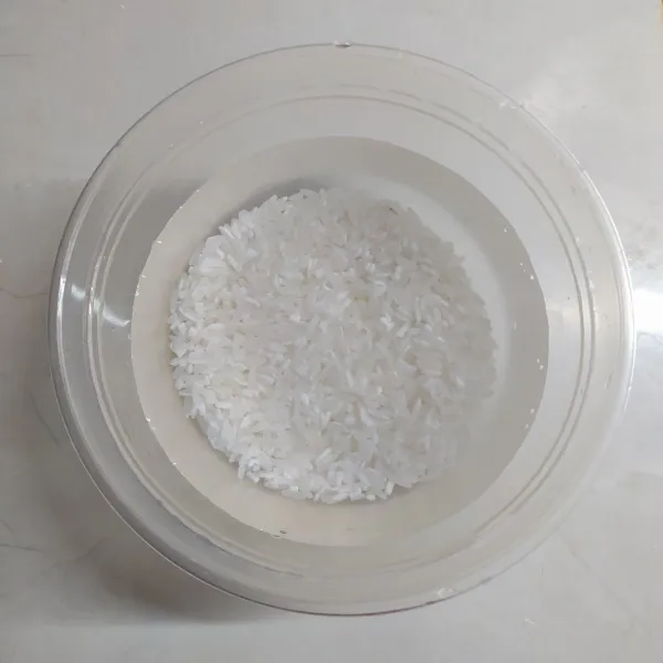 Cuci bersih beras, rendam dalam air selama 1 jam minimal lalu tiriskan.
