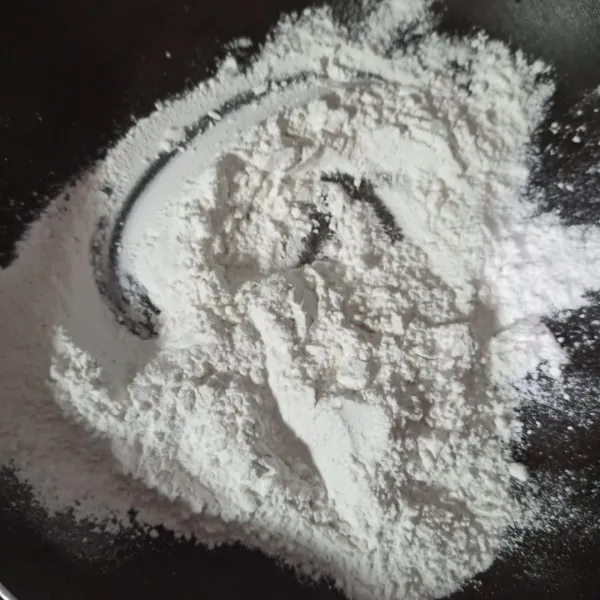 Campur tepung beras, tepung tapioka dan garam di wajan anti lengket.