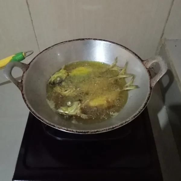 Panaskan minyak goreng. Goreng ikan hingga kering, lalu angkat dan tiriskan.