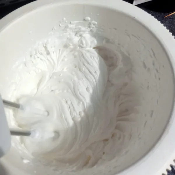 Kocok whipped cream sampai mengembang lalu masukkan cream cheese dan susu kental manis, kocok sampai kaku lalu sisihkan.