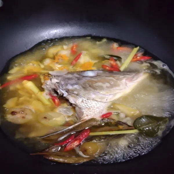 Masukkan kunyit bubuk, masak hingga mendidih dan ikan matang, koreksi rasa, tambahkan daun kemangi.