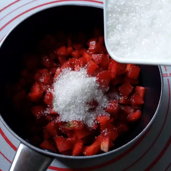 Buat Strawberry Compote : cincang kasar strawberry, tambahkan gula pasir, lalu aduk rata. Diamkan selama 5 menit atau sampai keluar cairan dari strawberry.