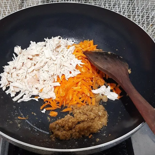 Masukkan wortel serut dan juga ayam suwir, lalu aduk rata.