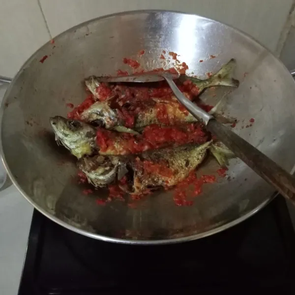 Masukkan gula pasir, garam, dan kaldu bubuk, lalu masukkan ikan goreng. Masak hingga bumbu meresap dan air menyusut, lalu matikan api. Kemudian sajikan.