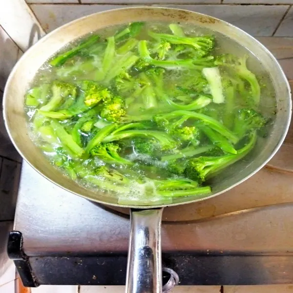 Panaskan air dalam wajan hingga mendidih dan masukan brokoli. Masak hingga lunak tapi tetap hijau, kemudian angkat.