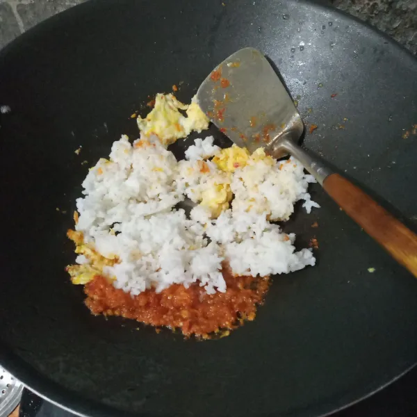Masukkan nasi, aduk rata. Lalu tambahkan garam dan kecap manis, aduk rata.