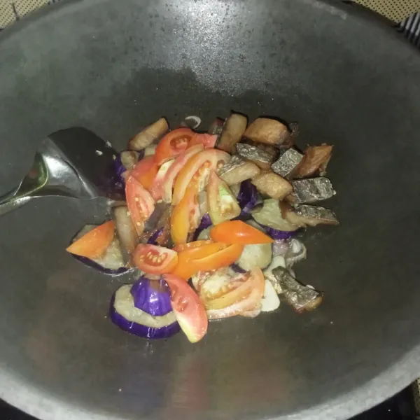 Masukkan ikan asin, terong dan tomat, aduk rata.