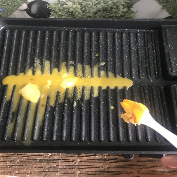 Panggang ayam di atas grill pan yang sudah di olesi margarin.