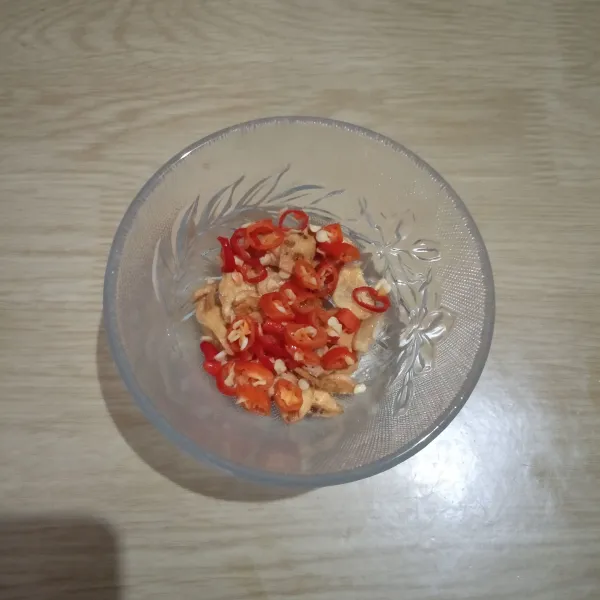 Taruh bawang putih goreng di mangkuk kecil, masukkan irisan cabai rawit.