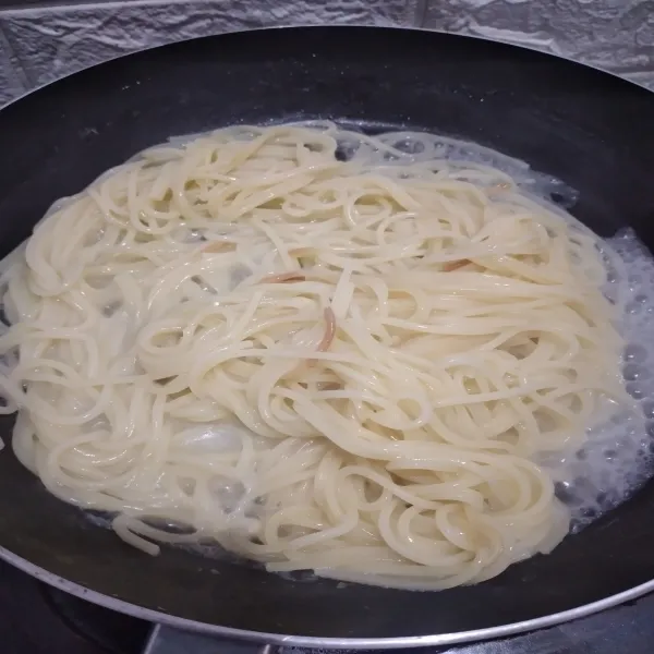 Didihkan air, beri sedikit minyak, masak spaghetti hingga al dente atau matang tapi tidak 100% supaya saat proses selanjutnya spaghetti tidak over-cooked, buang air, biarkan kompor masih menyala.