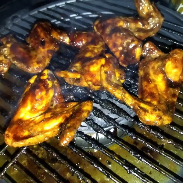 Lalu panaskan panggangan, setelah panas, tata saya ayam diatasnya, lalu oles semua permukaan sayap ayam dengan bahan oles.
