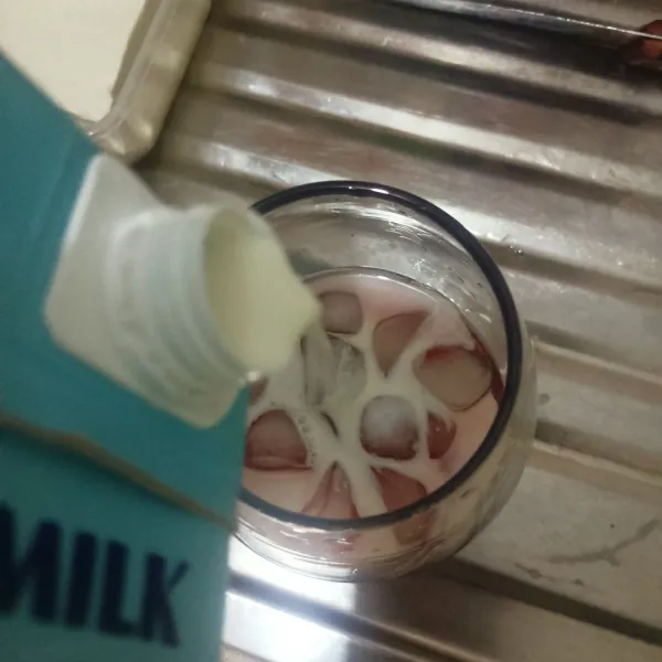 Terakhir tuang susu. Es stroberi milky siap dihidangkan.
