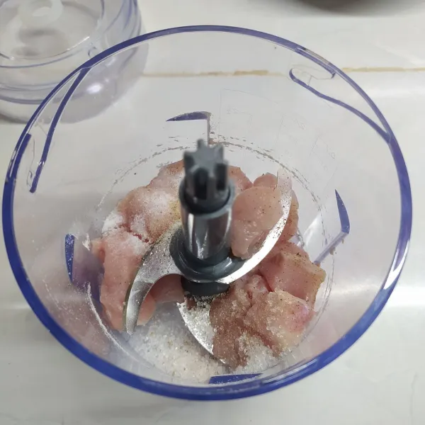 Masukkan daging ayam, bawang putih, garam, kaldu jamur, gula pasir, merica bubuk, dan 1 butir telur ke dalam food processor. Proses dengan kecepatan tinggi sampai halus.