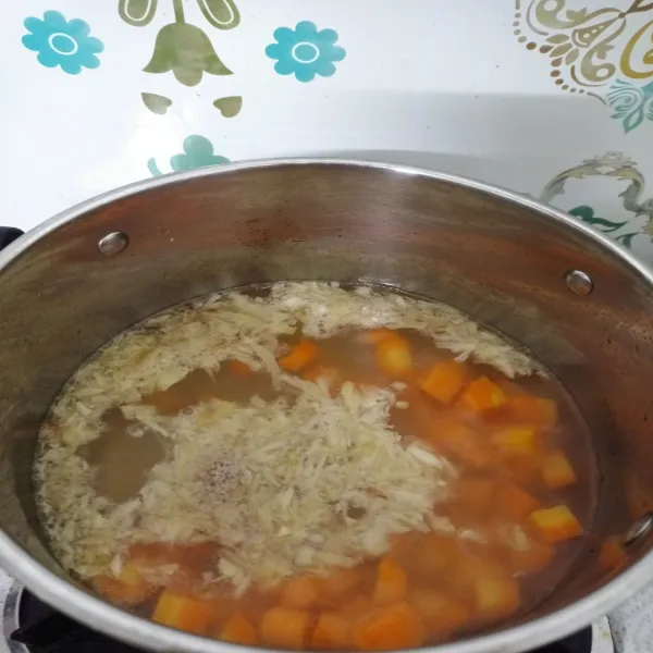 Tumis bawang putih hingga agak kecokelatan. Tambahkan air, lalu didihkan. Masukkan wortel, masak hingga setengah matang.