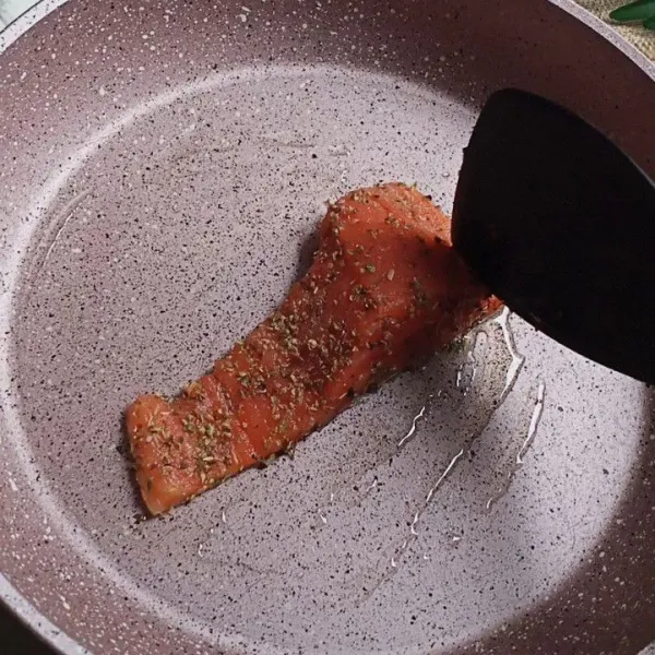 Setelah pan dan minyak panas, masukkan salmon bagian kulitnya dulu. Tunggu hingga bagian kulit krispi.