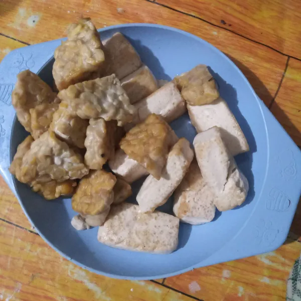 Potong-potong tahu dan tempe, lalu goreng setengah matang. Kemudian angkat dan tiriskan.