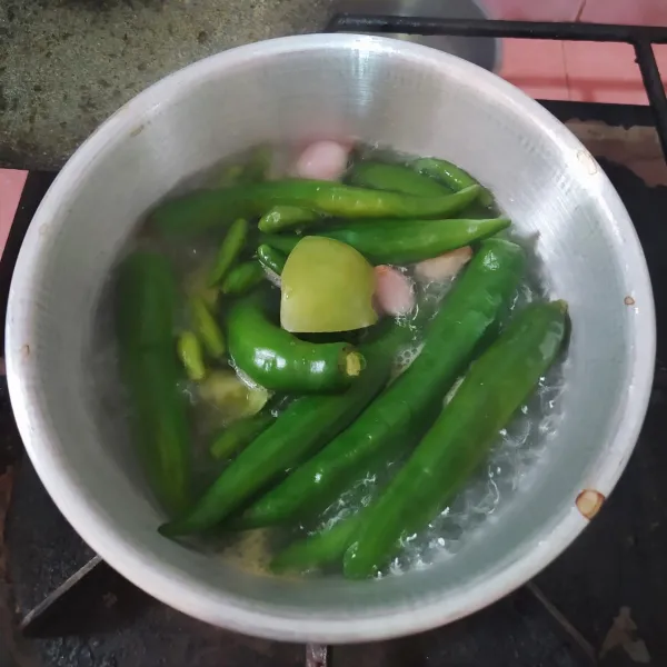 Didihkan air, lalu masukkan cabe hijau besar, cabe hijau rawit, tomat hijau, bawang putih, bawang merah dan kemiri sangrai. Rebus selama 5 menit, kemudian angkat dan tiriskan.