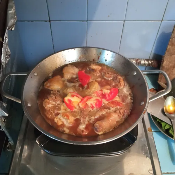 Masukkan potongan tomat dan air asam, aduk kembali, masak hingga ayam empuk dan kuah mengental.
