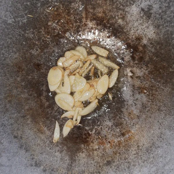 Goreng bawang putih yang sudah diiris tipis.