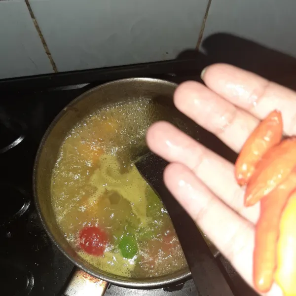 Tambahkan cabai, kalau mau lebih pedas sebagian cabai dipotong kecil-kecil atau diulek.