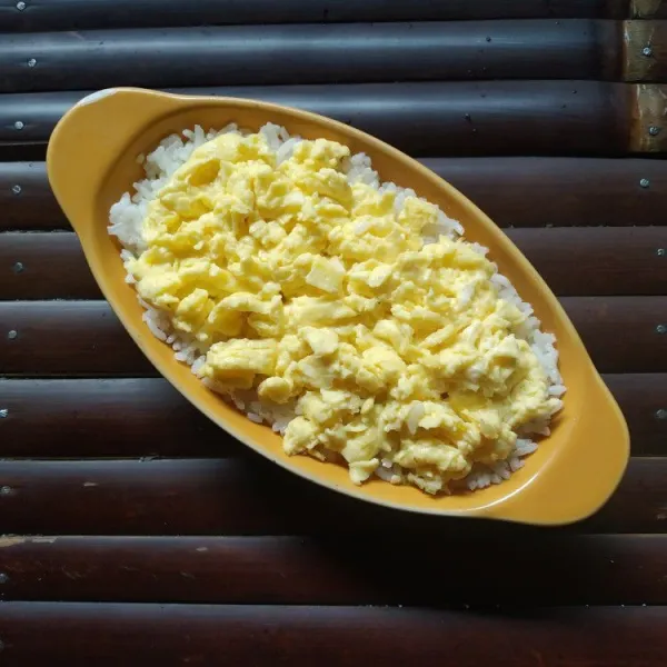 Susun scrambled egg diatas nasi, padatkan.