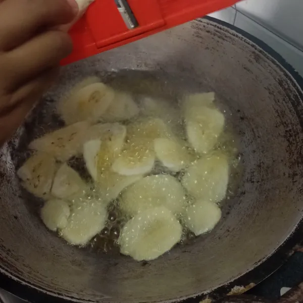 Panaskan minyak lalu parut pisang di atasnya langsung 2-3 pisang. 
Setelah penuh, tuang 2-3 sdm air bumbu.