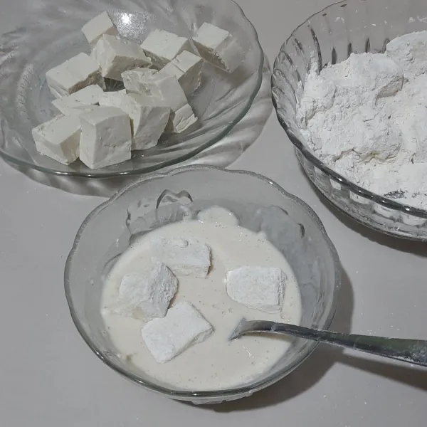 Lalu ambil 3 sdm campuran tepung dan tambahkan sedikit air, lalu celupkan tahu yang sudah di lumuri tepung.